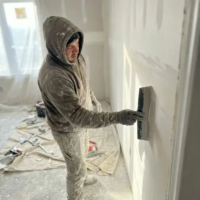 In-house finisher skimming a wall joint on an Elgin job site