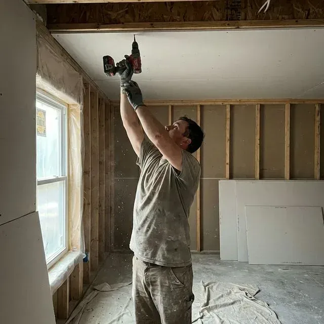 Drywall sheets going up on new framing in an Elgin, IL room